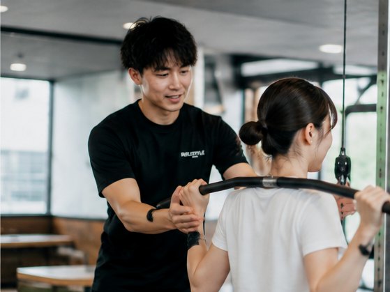 トレーナーがお客様のフォームを確認しながら指導している様子